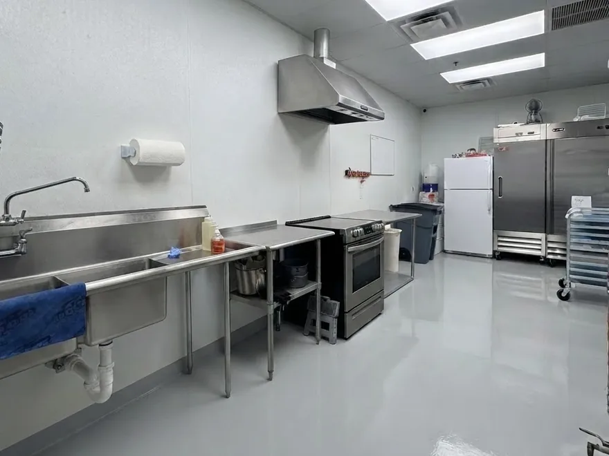A clean, empty formulation room with stainless steel benches