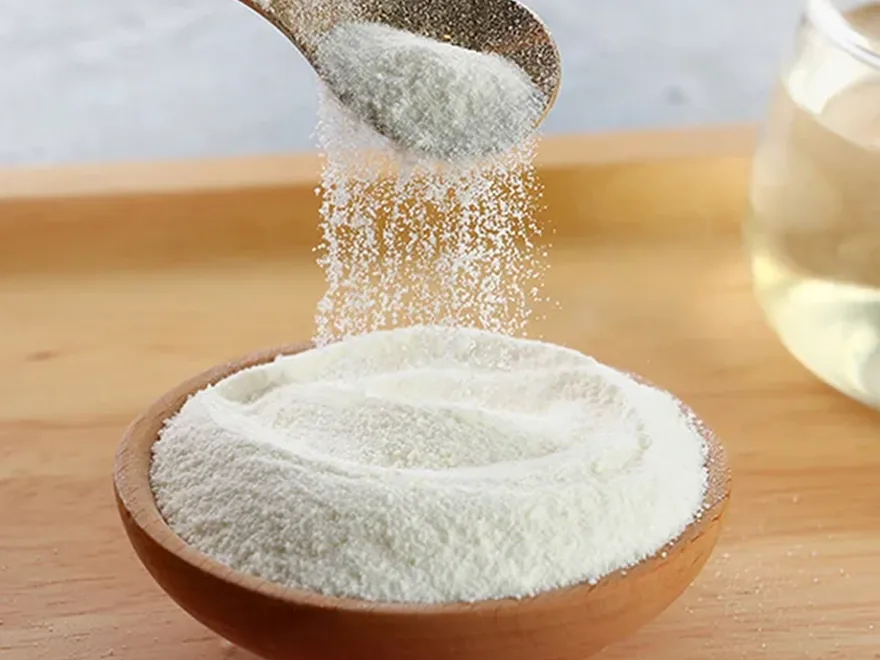 A spoonful of fine supplement powder being poured into a bowl